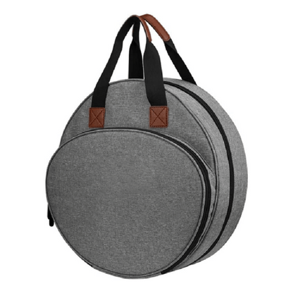 The Embroidery Storage Bag is round and gray, with two black handles and brown leather accents. It has two zippered compartments, making it perfect for organizing your embroidery essentials while combining functionality and style.