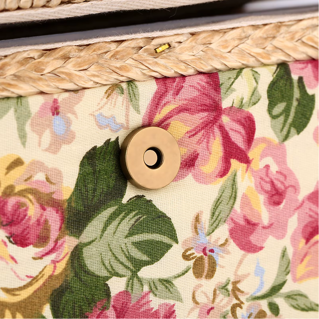 A close-up of the Extra Large Vintage Sewing Basket reveals beige floral fabric with pink and green patterns, adorned with a gold metallic button and braided trim, exuding vintage charm.