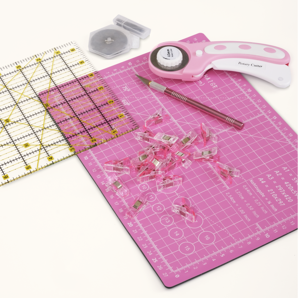 The 39-Piece Quilting Kit: Perfect for Beginners includes a pink cutting mat, clear ruler, rotary cutter, spare blade, precision craft knife, and sewing clips—ideal for sewing projects or enhancing your essential quilting kit.