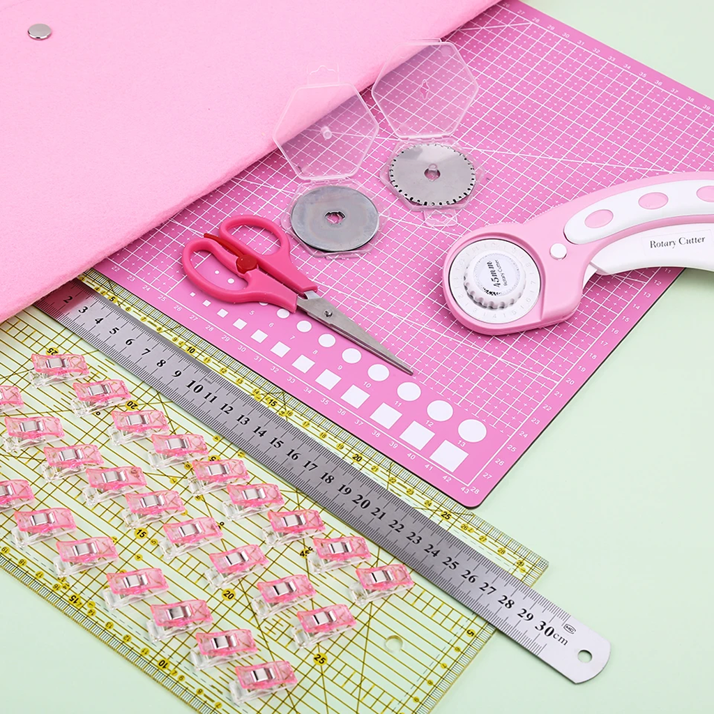 The 39-Piece Quilting Kit: Perfect for Beginners, including a rotary cutter, scissors, acrylic ruler, cutting mat, templates, and sewing clips, is arranged on a pastel pink and green background.