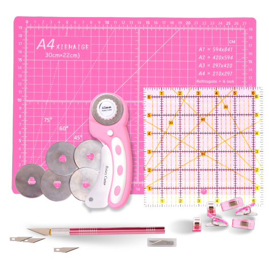 The 39-Piece Quilting Kit: Perfect for Beginners includes a pink cutting mat, rotary cutter with spare blades, square ruler, craft knife, fabric clips, and more—everything a new quilter needs in one organized set.