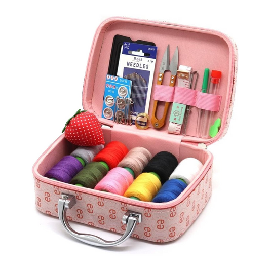 The Sewing Kit In a Stylish Box includes spools of thread, needles, scissors, measuring tape, buttons, a seam ripper, and a strawberry-shaped pincushion in an open pink compact case.