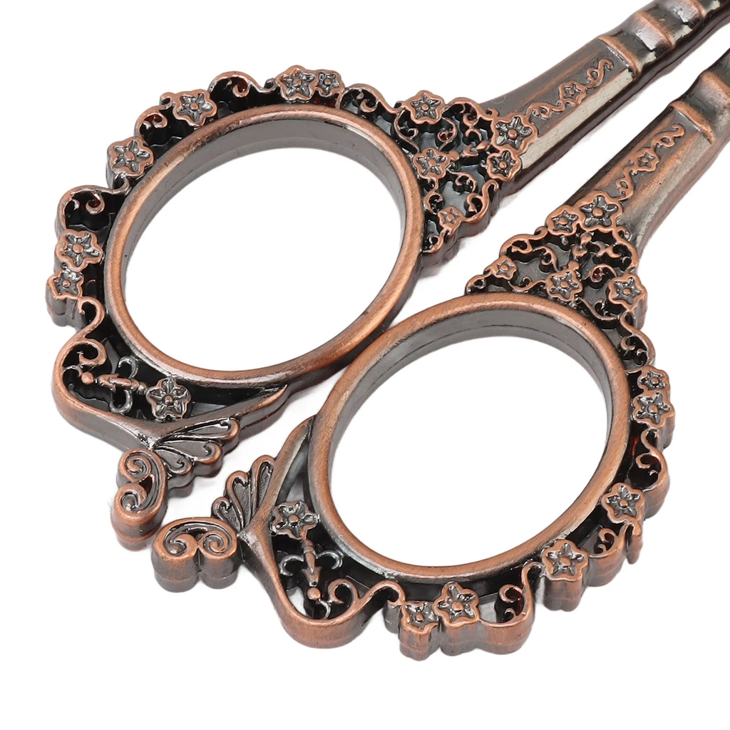 Close-up of ornate scissors with an antique bronze finish featuring intricate floral designs on the handles, ideal for a Vintage Antique Sewing Kit.
