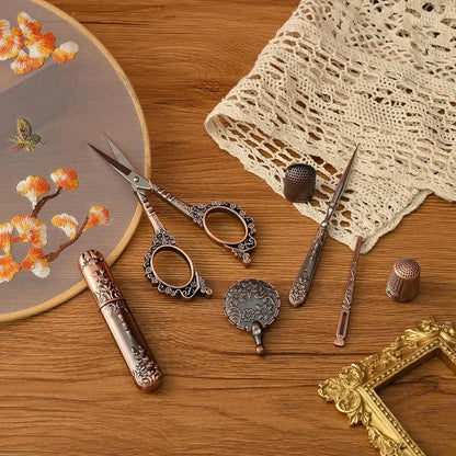 The Vintage Antique Sewing Kit includes embroidery tools like scissors, thimbles, a needle case, and lace fabric elegantly displayed on wood with an embroidery hoop. Its antique bronze finish enhances the charm of this compact wooden artistry case.