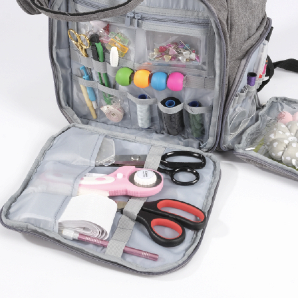 The Premium Quilting Organizer Backpack, crafted from durable 600D Oxford fabric, opens to reveal organized compartments stocked with sewing and quilting tools such as scissors, thread spools, measuring tape, pins, and more.