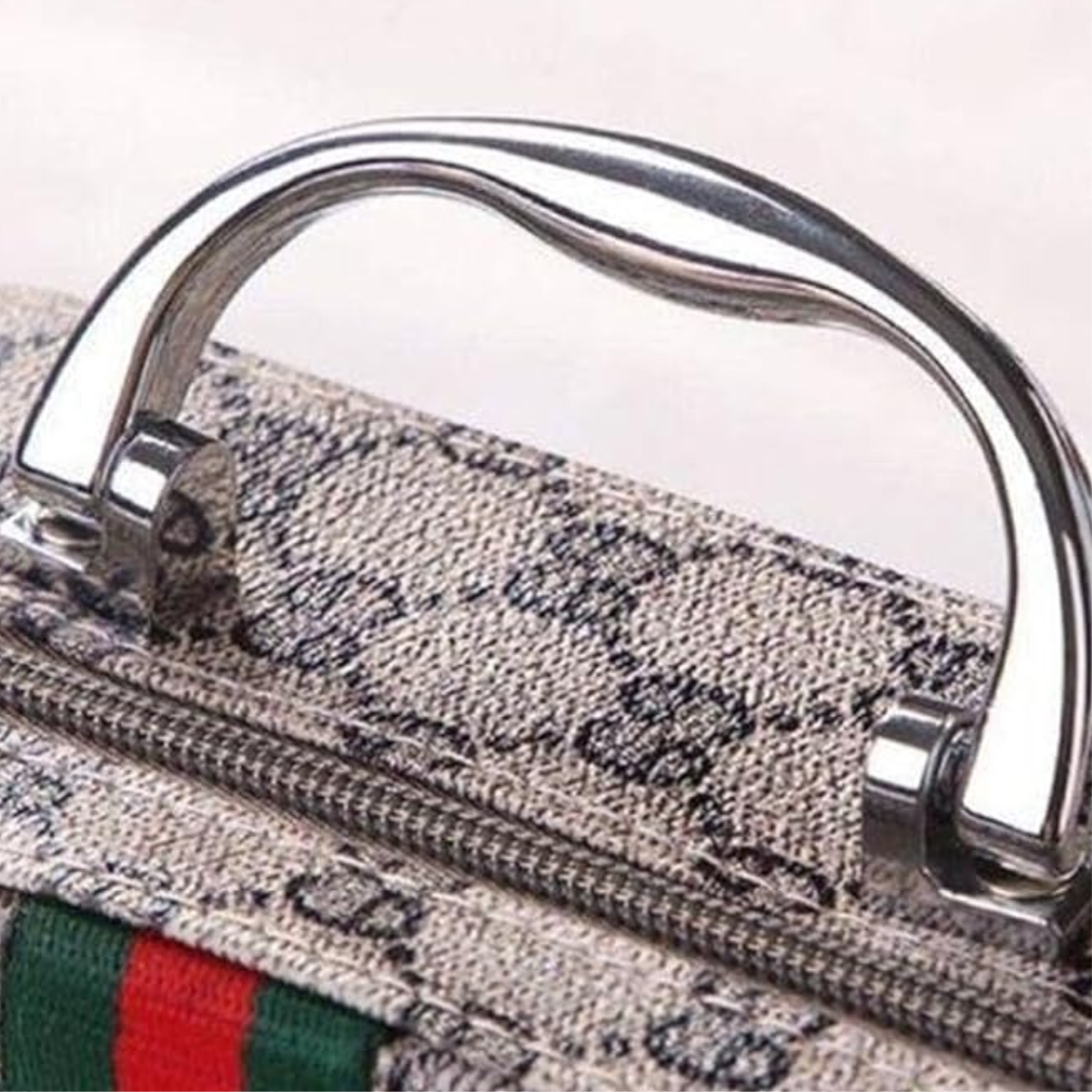 Close-up of the metallic handle on the Sewing Kit In a Stylish Box, featuring a zipper and green and red striped fabric detail—ideal for carrying your compact sewing essentials.